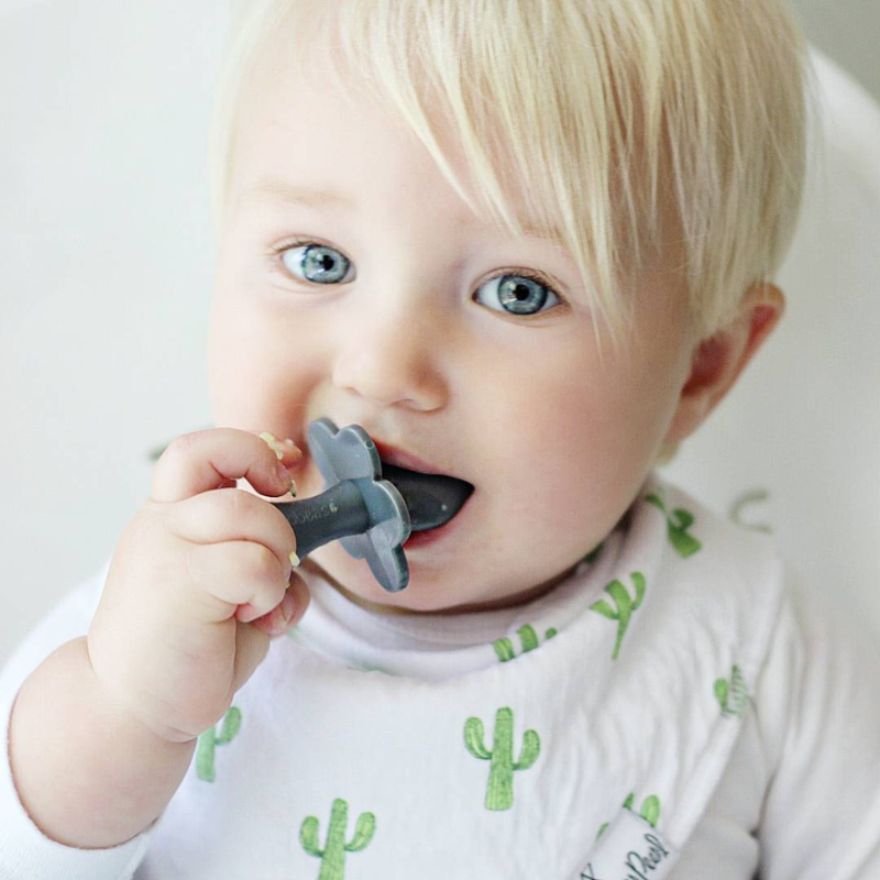 A toddler using the best-selling grabease short-handled self-feeding spoon to eat. 