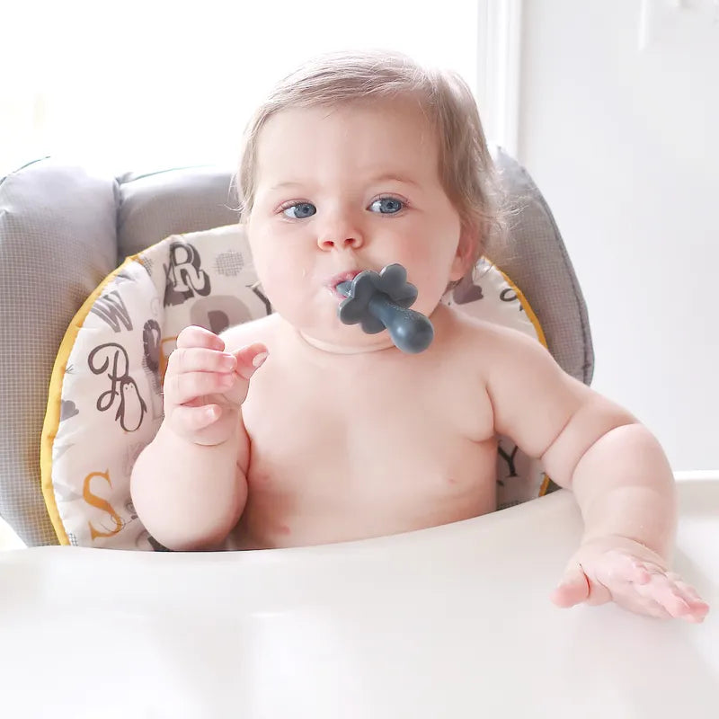 Chubby Baby with a grabease infant spoon in her mouth