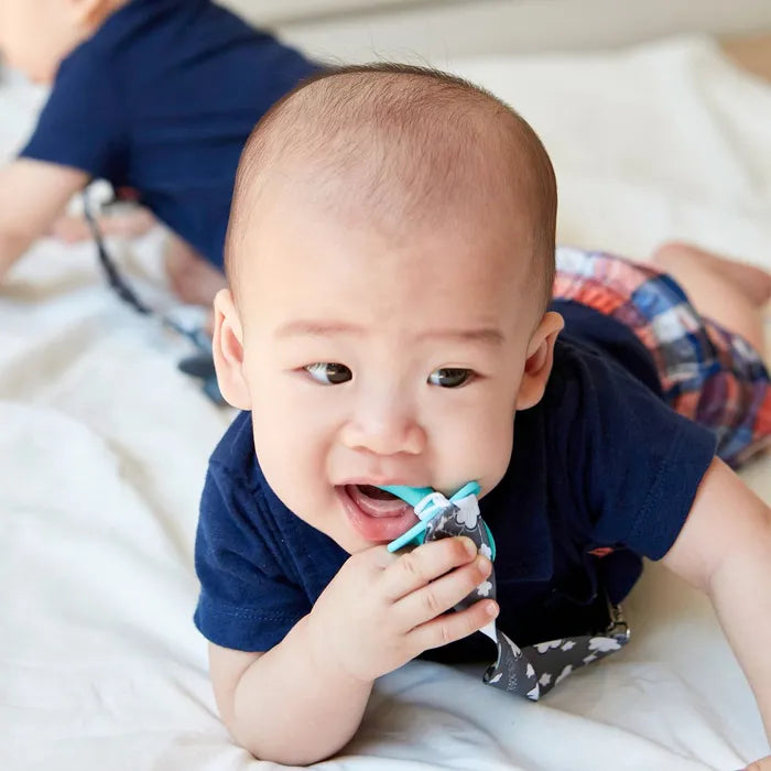 A baby chewing on a silicone infant spoon 