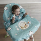 A laughing baby in the Grabease Allover Bib-Smock bib & high-chair cover